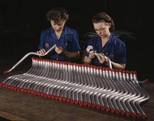 Two women workers are shown capping and inspecting tubing...Vultee's Nashville..., Tennessee, 1943. Creator: Alfred T Palmer.