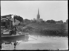 Norwich Cathedral from Pull's Ferry, with men on a boat in the foreground, Norwich, Norfolk, 1920-38 Creator: George R Long.