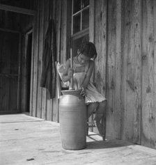 Daughter of Negro tenant churning butter. Randolph County, North Carolina, 1939. Creator: Dorothea Lange.