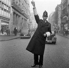 An informal portrait of a traffic policeman standing in the road, City of London, c1946-c1959. Artist: John Gay