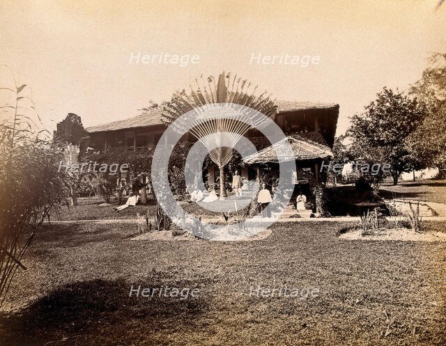 Singapore: a large bungalow with people having drinks in the garden around a large..., 1881. Creator: John Edmund Taylor.