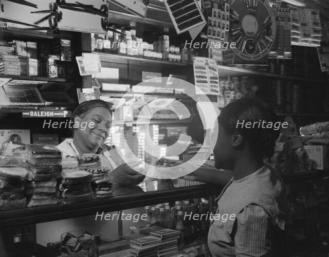 Clerk waiting on a customer in the store owned by Mr. J. Benjamin, Washington, D.C., 1942. Creator: Gordon Parks.