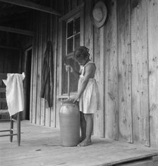 Pottery butter churn on porch of Negro tenant family, Randolph County, N Carolina, 1939. Creator: Dorothea Lange.