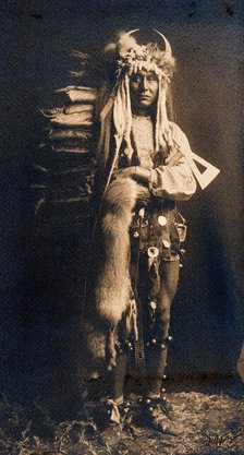 A Piegan man, Iron Breast, in ceremonial dress, 1900. Creator: Edward Sheriff Curtis.