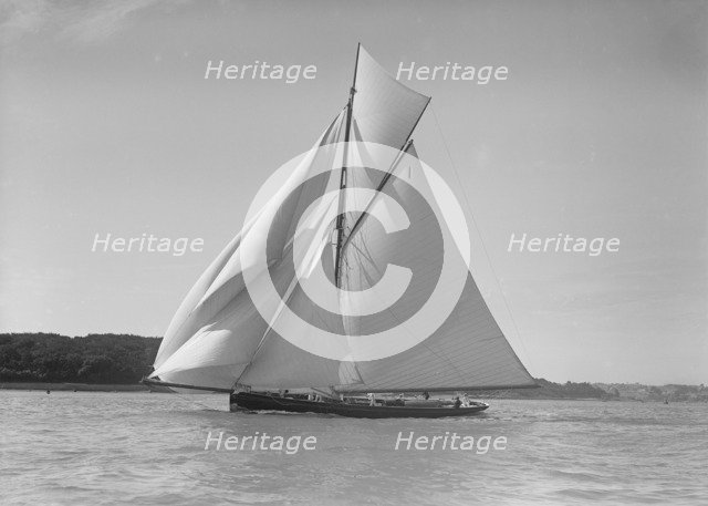 The gaff rigged cutter 'Bloodhound' sailing downwind under spinnaker, 1911. Creator: Kirk & Sons of Cowes.