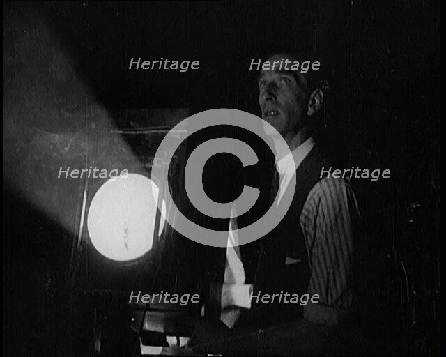 Male Civilian Stands Next to a Large Light, 1920s. Creator: British Pathe Ltd.