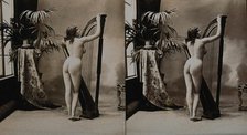 A young woman posing naked in a photographic studio, standing with her back to the camera..., c1900. Creator: Unknown.