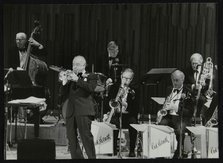 The Ted Heath Orchestra in concert, London 1985. Pictured are Lennie Bush (double bass), Kenny Baker Artist: Denis Williams