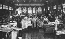 The interior of Billingsgate Market showing fishmongers and their stalls, London, c1918. Artist: Unknown