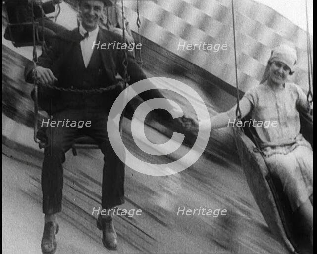 A Male Civilian and a Female Civilian Holding Hands as They Are Spun Through the Air on a..., 1924. Creator: British Pathe Ltd.