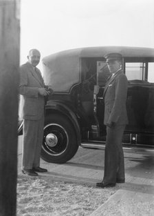 Rothbart, Albert, Mr., standing by his car with his chauffeur, between 1920 and 1935. Creator: Arnold Genthe.