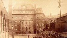 Bellevue Hospital, New York City: hospital buildings with a tower; a pile of bricks in the fore... Creator: Unknown.