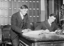 Two new citizens sign naturalizaton papers in judge's chambers, 1910. Creator: Bain News Service.