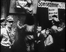 Men in Nazi Uniforms attaching anti-Jewish Posters, 1933. Creator: British Pathe Ltd.