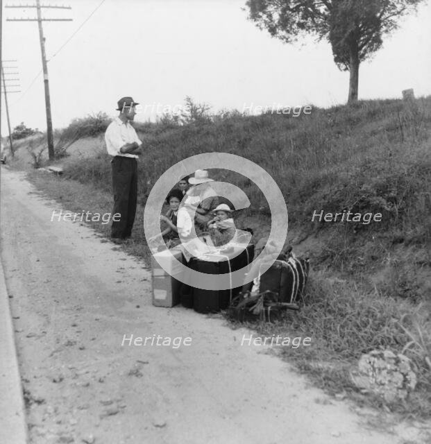 A hitchhiking family waiting along the highway in Macon, Georgia, 1937. Creator: Dorothea Lange.