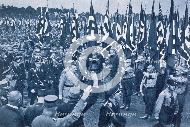 Adolf Hitler, escorted by SS leaders, inspects the SA at a Nazi rally in Nuremberg, 1933. Artist: Unknown