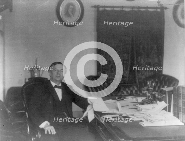 John Wanamaker, 1838-1922, three-quarter length portrait, seated, at desk, facing right, c1890. Creator: Frances Benjamin Johnston.