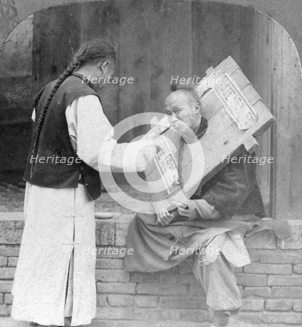 Feeding a prisoner wearing a cangue, China, 1902. Artist: CH Graves