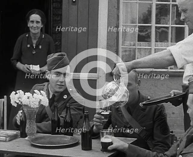 American Airmen Drinking Outside a Public House in England, and Being Served by..., 1943-1944. Creator: British Pathe Ltd.