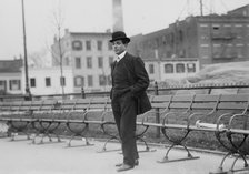 Umberto Blaisie standing in front of park benches, 1910. Creator: Bain News Service.