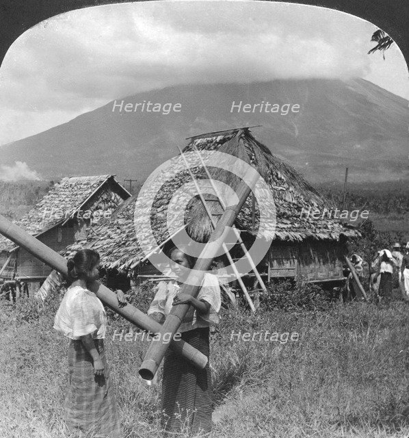 Native girls with their water vessels made from shafts of bamboo, Philippines, 1907. Artist: HC White