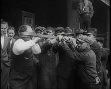 A Male Stuntman Bending Iron Bars Around His Head, 1926. Creator: British Pathe Ltd.