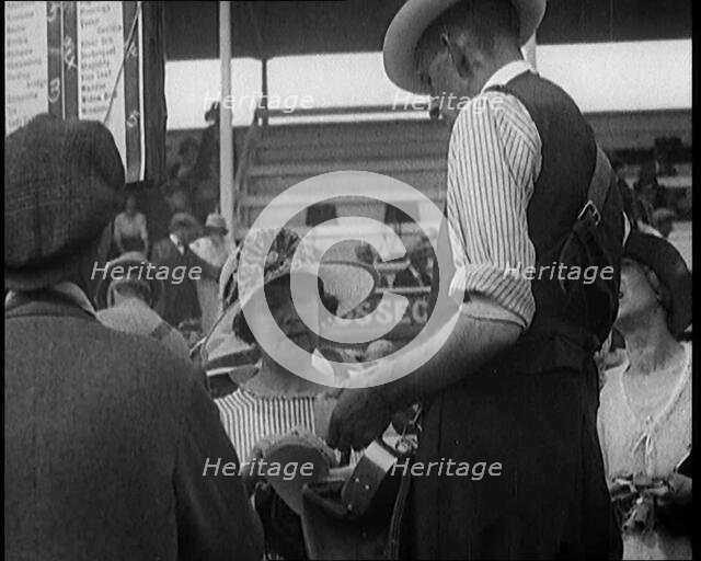 A Female Civilian Placing a Bet with a Bookie in a Horse Racing Event, 1920. Creator: British Pathe Ltd.