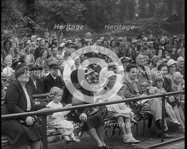 British People Watching Chimpanzees Having a Tea Party at the Zoo, 1940. Creator: British Pathe Ltd.