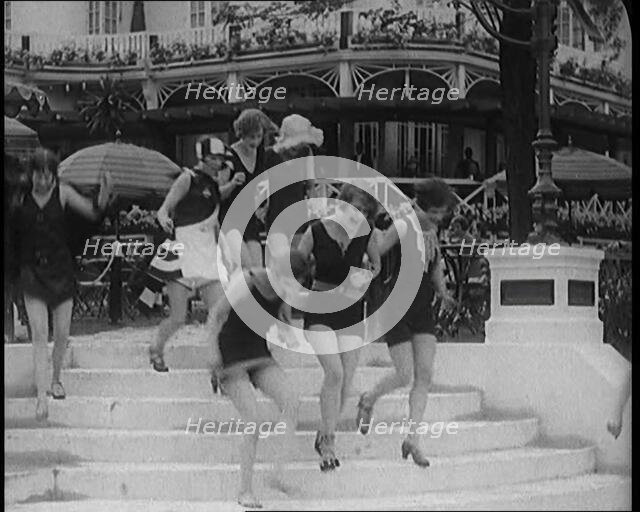 A Group of Young Female Civilians Running down Some Steps Wearing Swimsuits, 1920. Creator: British Pathe Ltd.