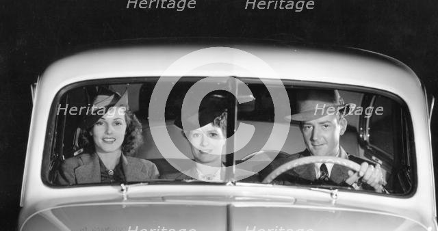 1939 Oldsmobile driver and female passengers. Creator: Unknown.