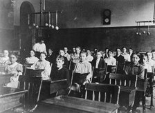 Boys and girls seated at desks in Washington, D.C. classroom, (1899?). Creator: Frances Benjamin Johnston.