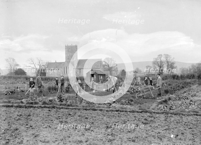 Schoolboys working in the school garden supervised by a teacher, Uffington, Oxfordshire, 1916. Artist: FW Ault