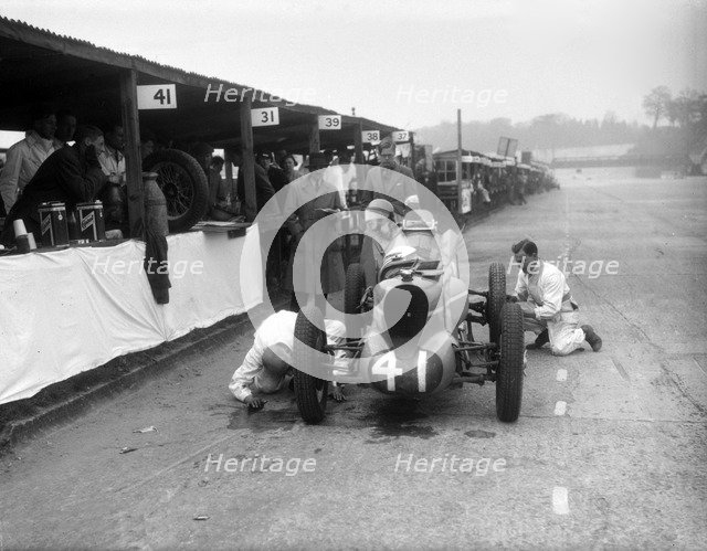 Mechanics working on the MG of Doreen Evans, JCC International Trophy, Brooklands, 1936. Artist: Bill Brunell.