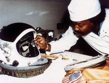 Technician installing eye-glasses in helmet. Creator: NASA.