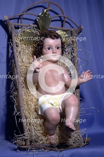 Figure of baby Jesus in the crib.