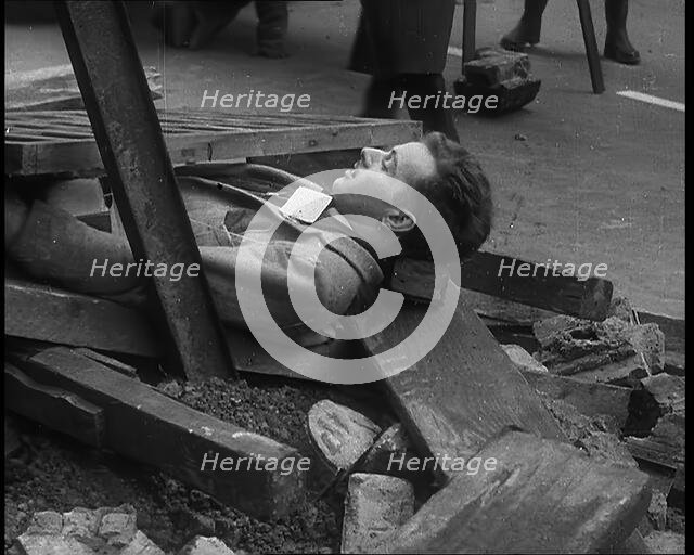 British People Acting Out Bomb attacks and Crashed German Planes, Lying Under Rubble, 1940. Creator: British Pathe Ltd.