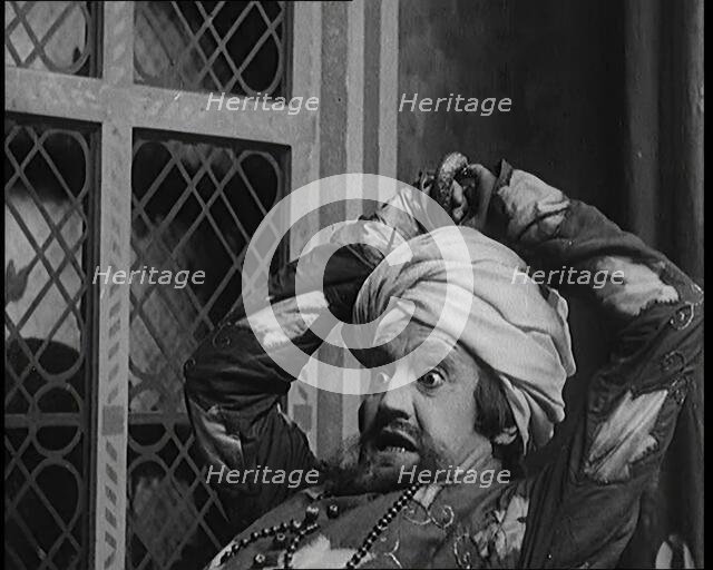 Scene from the Play 'Hassan': the Actor Henry Ainley in Full Costume Raising a Sword..., 1920s. Creator: British Pathe Ltd.