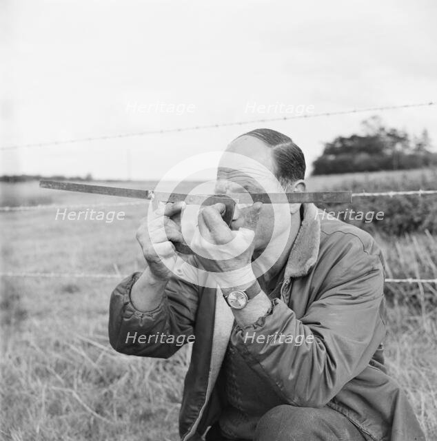 A man holding a surveyor's protractor working on the route of the Mersey oil pipeline, 24/09/1967. Creator: John Laing plc.
