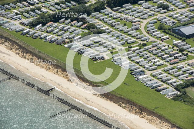 Coastal erosion between a caravan park and the sea defences at Corton Cliffs, Suffolk, 2019. Creator: Historic England.
