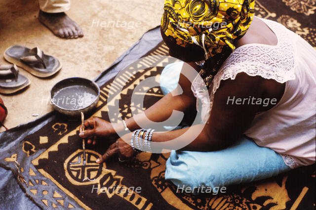 Woman painting with mud from the River Niger, Djenné, Mali, 1990. Creator: Amanda Waite.
