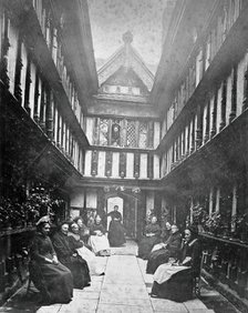 Ford's Hospital, Coventry: residents seated in the courtyard looking toward the street, c1880s. Creator: Unknown.