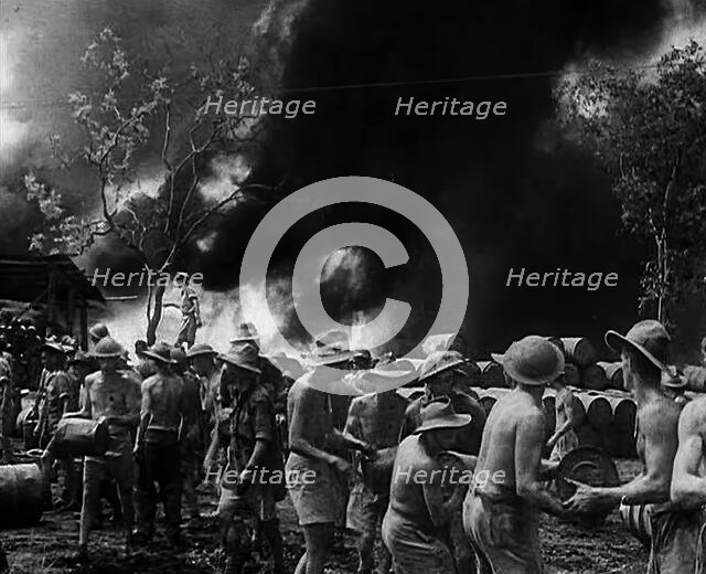 Commonwealth Troops Watching Flames and Smoke Emitting from a Supply Dump, 1941. Creator: British Pathe Ltd.