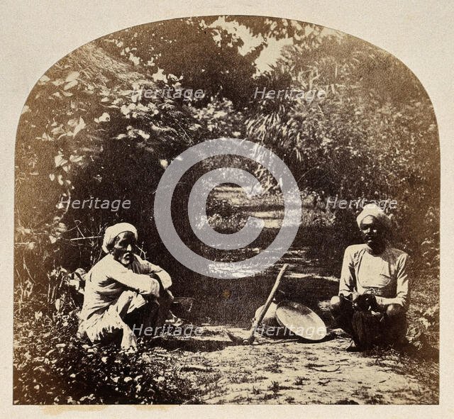 Goruckpoor, India: two men sqatting on a tree-lined path, c1860s. Creator: Unknown.