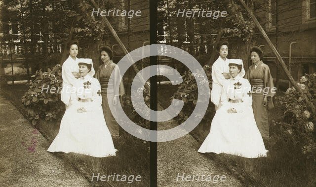 A western Red Cross female doctor(?) and two Japanese women posed in a garden, c1905. Creator: Underwood & Underwood.