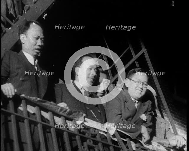 Male Civilians Watching a Female Civilian in Traditional Robe Performing With Sabres in..., 1932. Creator: British Pathe Ltd.