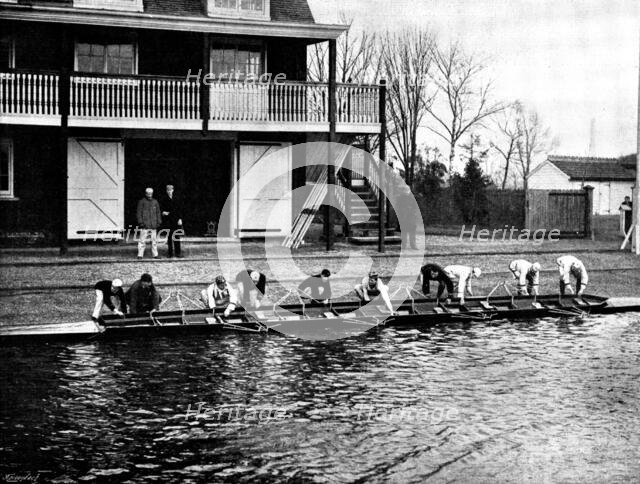 The Universities' Boat-Race: the Cambridge crew at practice - putting in the boat, 1895. Creator: Stearn.
