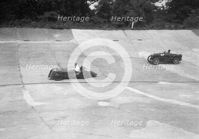 Austin 747 cc with sreamlined racing body leading an MG C type on the Members Banking at Brooklands. Artist: Bill Brunell.