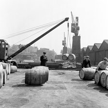 Unloading wine barrels, London Docks, 1953. Artist: Henry Grant