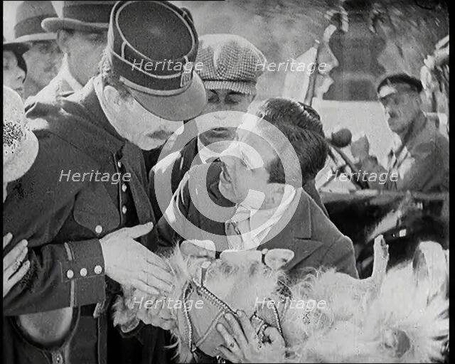 Scene from the Film 'The Compulsory Husband': Monty Banks Holding a Dog That He Has Run Over, 1920s. Creator: British Pathe Ltd.
