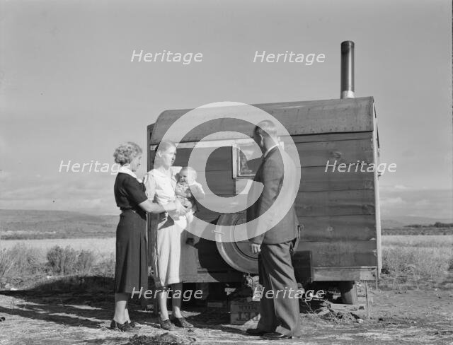 The doctor reassures the mother...the sick baby, Merrill, Klamath County, Oregon, 1939. Creator: Dorothea Lange.